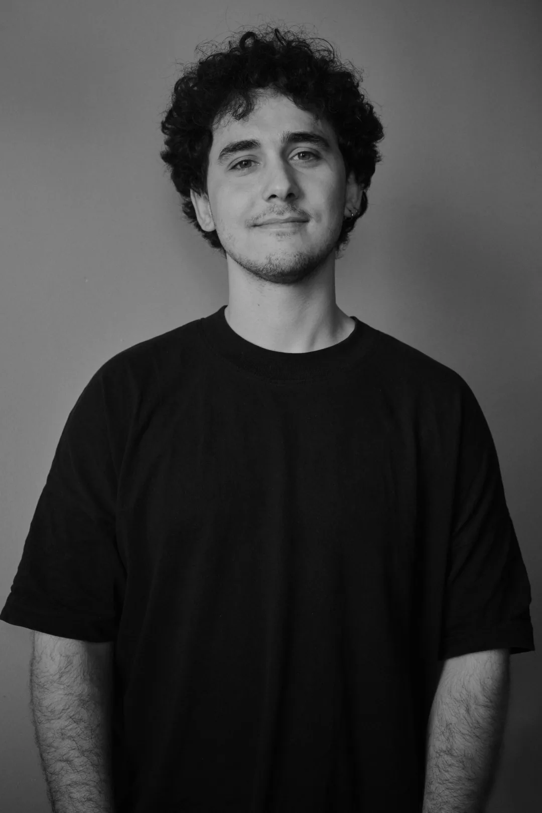 Portret alb-negru al lui Luca Misosniky, în tricou negru, pe fundal neutru